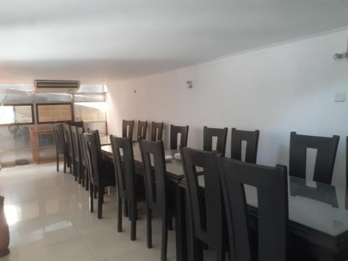 a dining room with a table and black chairs at Sanford Hotel & Restaurant Colombo in Wattala