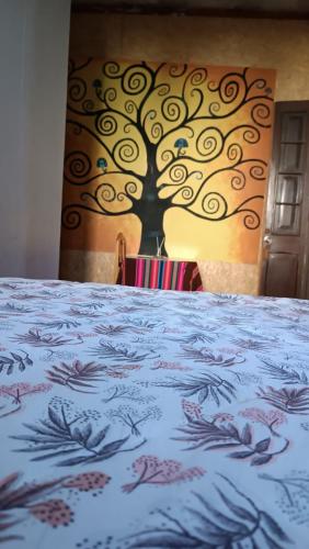 a bed with a tree painted on the wall at Holistic Scandinavia House in Arequipa