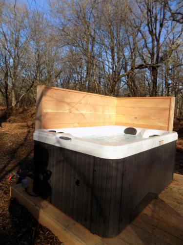 a jacuzzi tub sitting on a wooden deck at Tente luxe avec jacuzzi vue lac 3 in Le Vigeant
