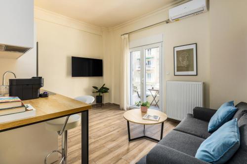 a living room with a couch and a table at Tropical & Faces by Nest in Thessaloniki