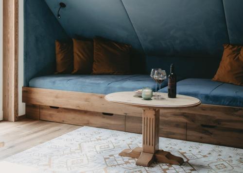 a table with a wine glass and a bed at Hotel Rosenhof Murau in Murau