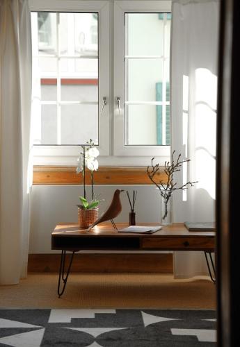 a desk in a room with two windows at Charming Historical Apartment in Zurich City Center Oldtown in Zurich