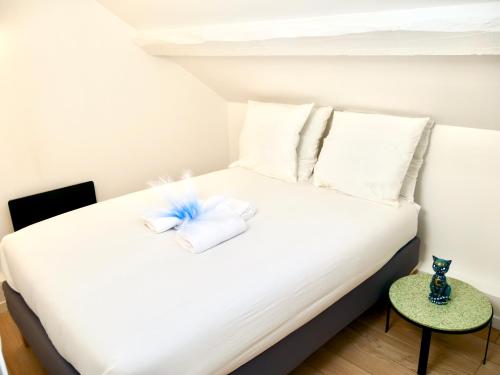 une chambre avec un lit blanc avec des oreillers blancs dans l'établissement Céleste Home, à Melun