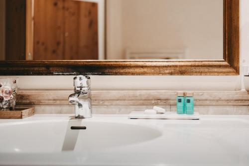a bathroom sink with a mirror and a toothbrush at Hotel Rosenhof Murau in Murau