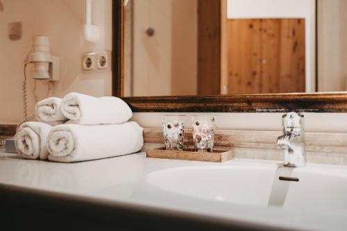 a bathroom sink with towels and a mirror at Hotel Rosenhof Murau in Murau