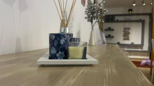 a glass of juice sitting on a table with two vases at Montijo Lux & Design Apartment in Montijo