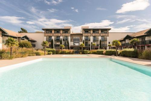 une grande piscine devant un immeuble dans l'établissement Village Moliets - maeva Home - Appartement 3 pièces 5 personnes - Sélection MAE-6641, à Moliets-et-Maa