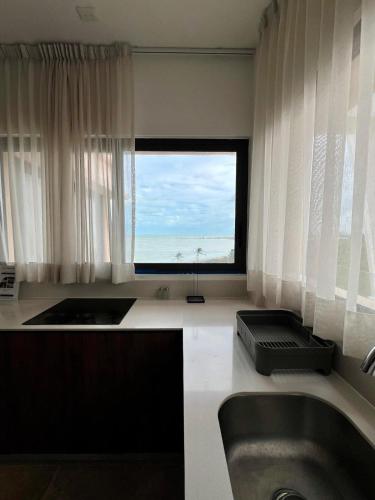 a bathroom with a tub and a large window at Penthouse Navela 405 by Cercana in Telchac Puerto