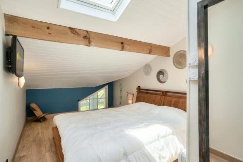 une chambre avec un lit blanc et une lucarne dans l'établissement Village Moliets - maeva Home - Appartement 3 pièces 5 personnes - Sélection MAE-6641, à Moliets-et-Maa