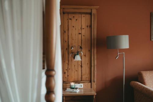 a room with a wooden wall with a lamp and a table at Hotel Rosenhof Murau in Murau