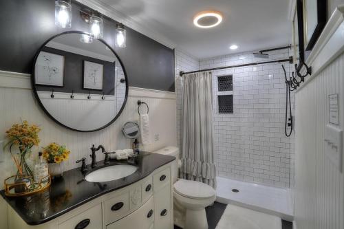 a bathroom with a sink and a toilet and a mirror at Beautiful Spacious & Well-Stocked Downtown Home in Rangeley
