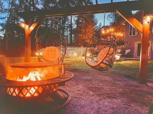 a fire pit in a yard with a swing at Beautiful Spacious & Well-Stocked Downtown Home in Rangeley