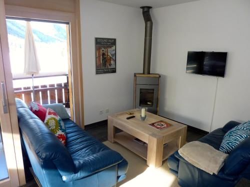 a living room with a blue leather couch and a table at Hotel Mont.Lac in Champex