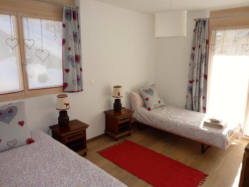 a bedroom with two twin beds and a window at Hotel Mont.Lac in Champex