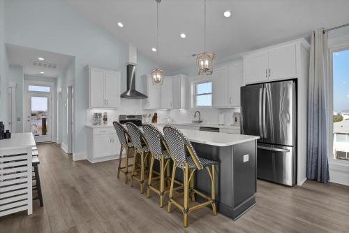 a kitchen with white cabinets and stainless steel appliances at Sunset Tide by Sea Scape Properties in North Topsail Beach
