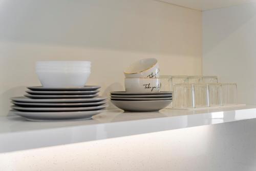 a white shelf with plates and bowls on it at Casa Myrtēssa in Myrtos