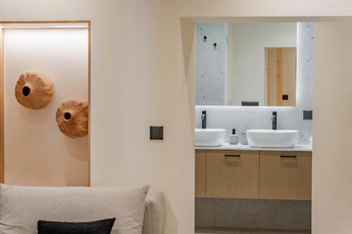 a bathroom with two sinks and a mirror at Casa Myrtēssa in Myrtos