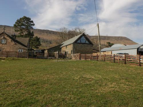 a farm with a wooden fence and a building at White Haywood Barn in Hereford