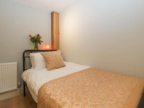 a bedroom with a bed with a vase of flowers on the wall at White Haywood Barn in Hereford