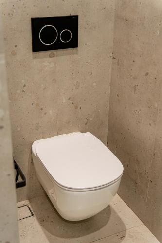 a toilet in a bathroom with two rings on the wall at Casa Myrtēssa in Myrtos