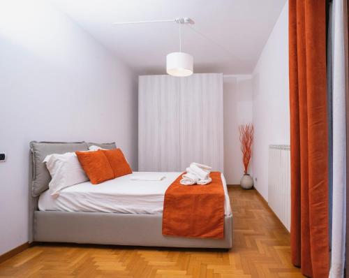 a bedroom with a bed with an orange blanket on it at Villa Antonella Wellness & Jacuzzi in Ciampino