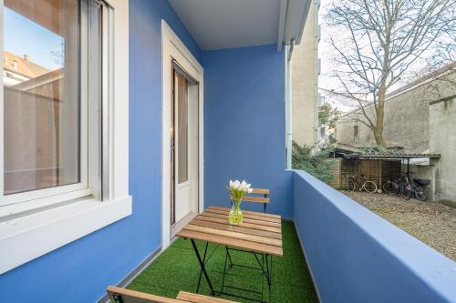a small table on the balcony of a blue house at Studio Apartment - Central - Kitchen - self check in in Basel