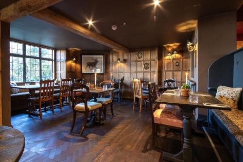 ein Restaurant mit Holzwänden und Tischen und Stühlen in der Unterkunft The White Hart, Wroughton in Swindon
