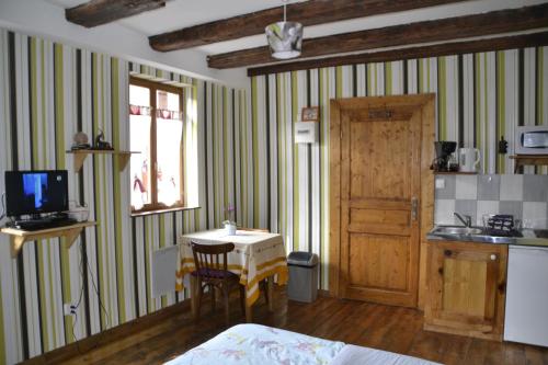 a room with a table and a kitchen with a door at Gîtes Du Stekala in Kaysersberg
