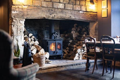 einen Steinkamin mit einem Herd in einem Zimmer in der Unterkunft The White Hart, Wroughton in Swindon