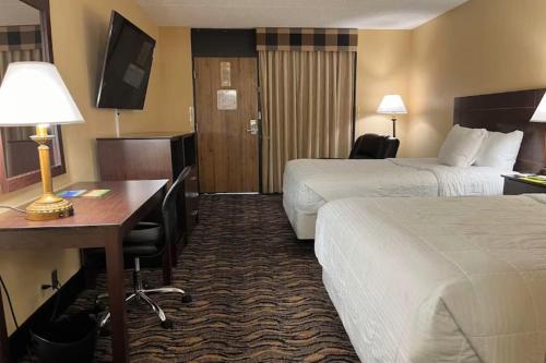 a hotel room with two beds and a desk at MCM Grande FunDome Odessa in Odessa