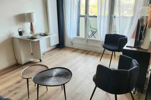a living room with two chairs and a table at Beautiful apartment with 3 balconies in Blonville-sur-Mer