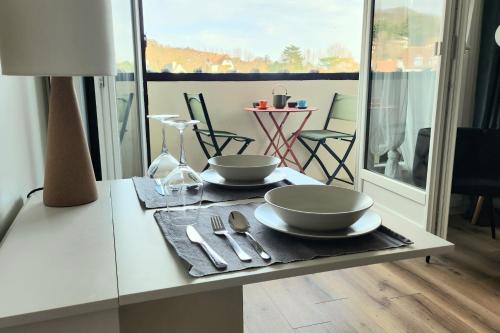 a table with two bowls and utensils on it at Beautiful apartment with 3 balconies in Blonville-sur-Mer