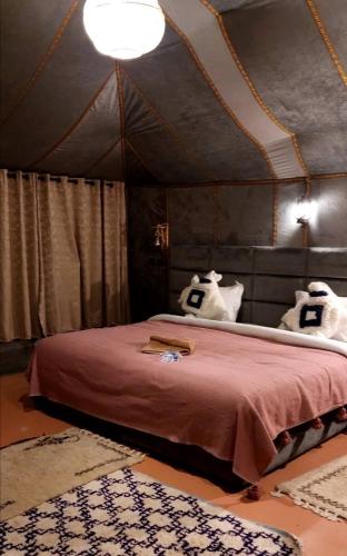 a bedroom with a bed in a tent at Infinity sahara camp in Merzouga