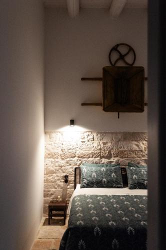 a bedroom with a bed and a stone wall at Casale Petrarolo in Monopoli