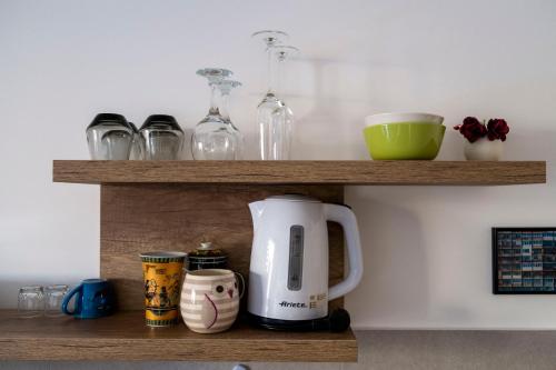 a coffee maker and cups on a wooden shelf at Planet Residence-Studio Solis in Niš