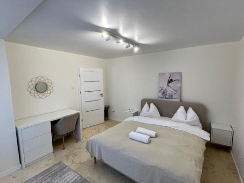 ein weißes Schlafzimmer mit einem Bett und einem Schreibtisch in der Unterkunft Central Premium Apartment in Iaşi
