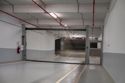an empty parking garage with a large metal gate at Planet Residence-Studio Solis in Niš