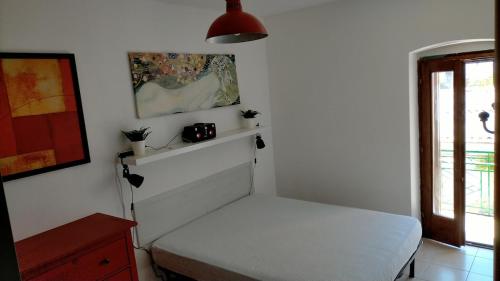 a small room with a white bed and a window at La casa di Lilith in Sennori