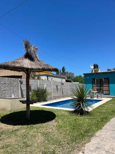 a straw umbrella sitting next to a swimming pool at casa de un ambiente in Funes