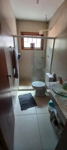 une salle de bain avec une douche, des toilettes et un lavabo dans l'établissement Casa de Madeira no Centro, à Miguel Pereira