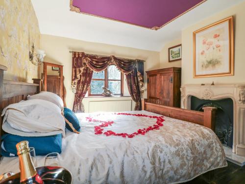a bedroom with a bed with a red flower on it at Woodpit Cottage in Nottingham
