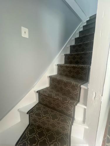 a stairway with a brown tile floor and white stairs at Walk to Everything Historic Arts District in Annapolis