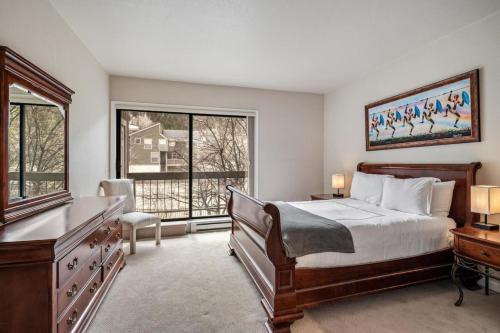 a bedroom with a bed and a desk and a window at Winter Getaway in the Rockies in Avon
