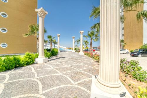 a sidewalk with columns in front of a building with palm trees at Caesar Resort & SPA - Apartment with 2 Bedroom - Aurelius in Saint Yeorgios