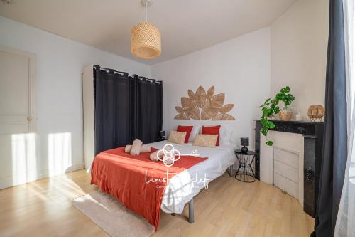 a bedroom with a bed with a red blanket at Fécomsi Escale - Un cocon au Mans - L'Instant Clef in Le Mans