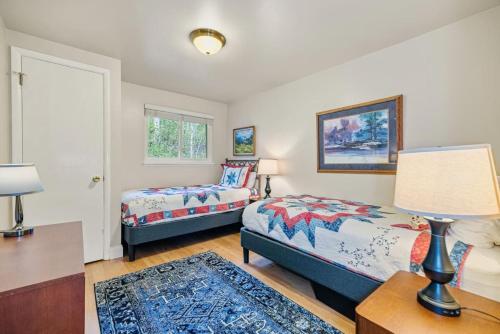 ein Schlafzimmer mit zwei Betten und einem Tisch mit Lampe in der Unterkunft Cozy Secluded Riverfront Cabin Fireplace Parking in Vail