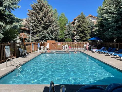 a large swimming pool with chairs in a yard at Edwards Mountain Chic On River Pool and Hot Tubs in Edwards
