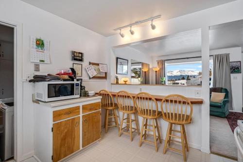 a kitchen with a counter with chairs and a microwave at Rocky Mountain Getaway For Budget Travelers in Leadville
