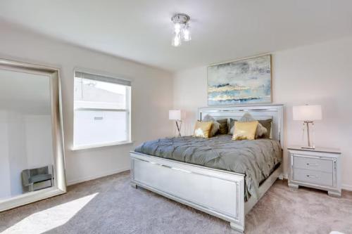 a bedroom with a bed with two lamps and a window at Sunset Harem Hideaway Port St Lucie in Port Saint Lucie