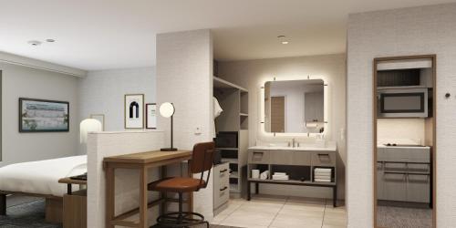 a hotel room with a bed and a desk and a bathroom at Homewood Suites By Hilton Jackson in Jackson